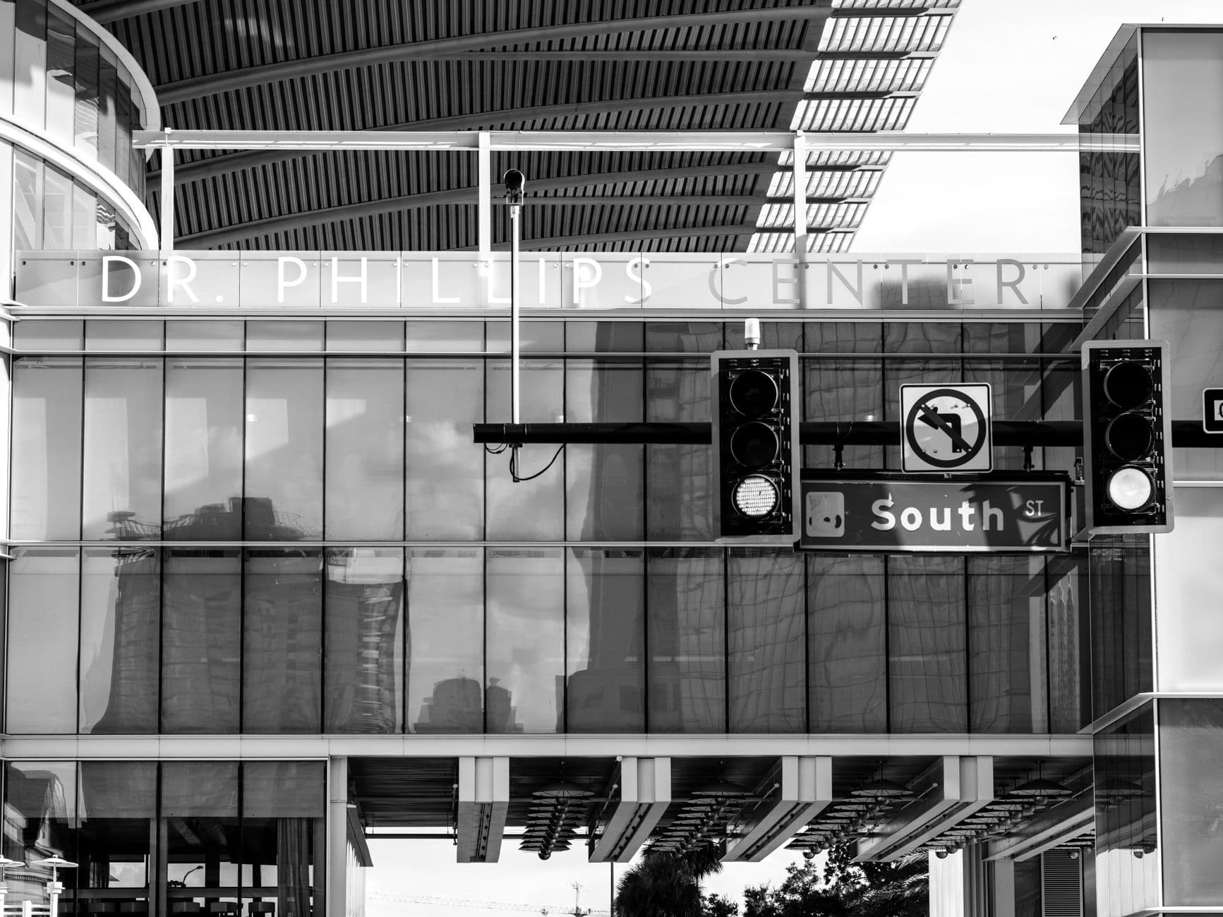 Monochrome urban scene of Dr. Phillips Center and street signs.