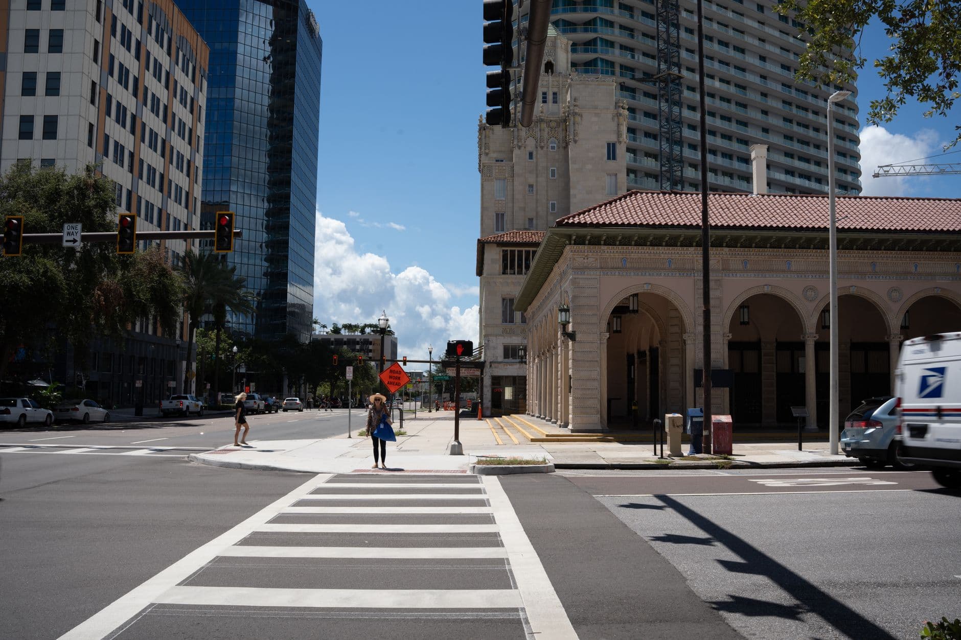 Street scene with historic building, modern skyscrapers, and pedestrians crossing at an intersection.